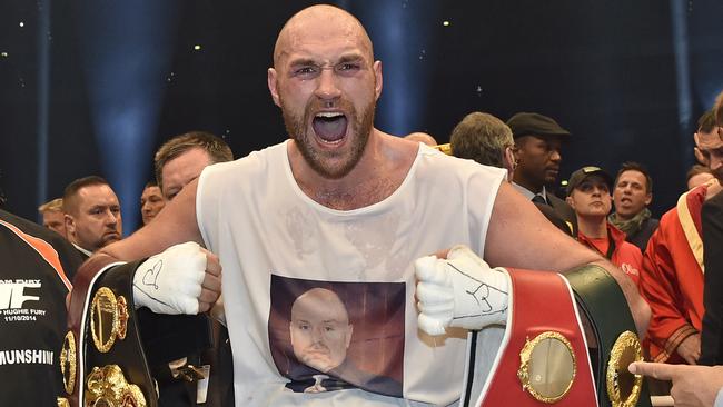 Britain's new world boxing champion Tyson Fury celebrates with the WBA, IBF, WBO and IBO belts.