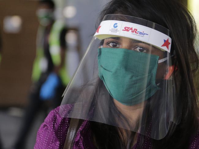 A passenger wearing face shield comes out from airport as domestic flights resume operations after a nearly two-month lockdown in India. Picture: AP