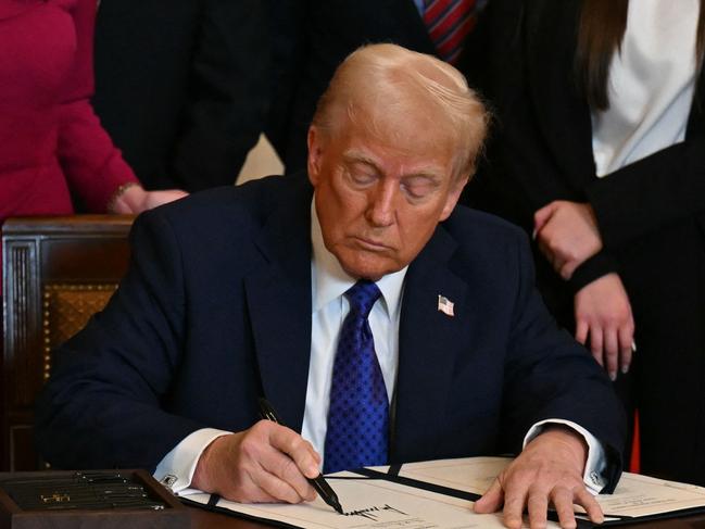 US President Donald Trump signs the Laken Riley Act in the East Room of the White House in Washington, DC, January 29, 2025. The Laken Riley Act -- which mandates the detention of undocumented immigrants charged with theft-related crimes -- is named for a 22-year-old student murdered by a Venezuelan man with no papers who was wanted for shoplifting. (Photo by PEDRO UGARTE / AFP)