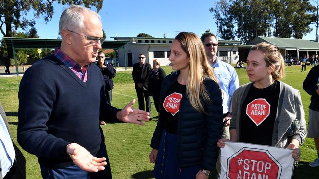 Prime Minister Malcolm Turnbull (left) is confronted by anti Adani coal mine protestors as he campaigns in the seat of Longman. Picture: AAP