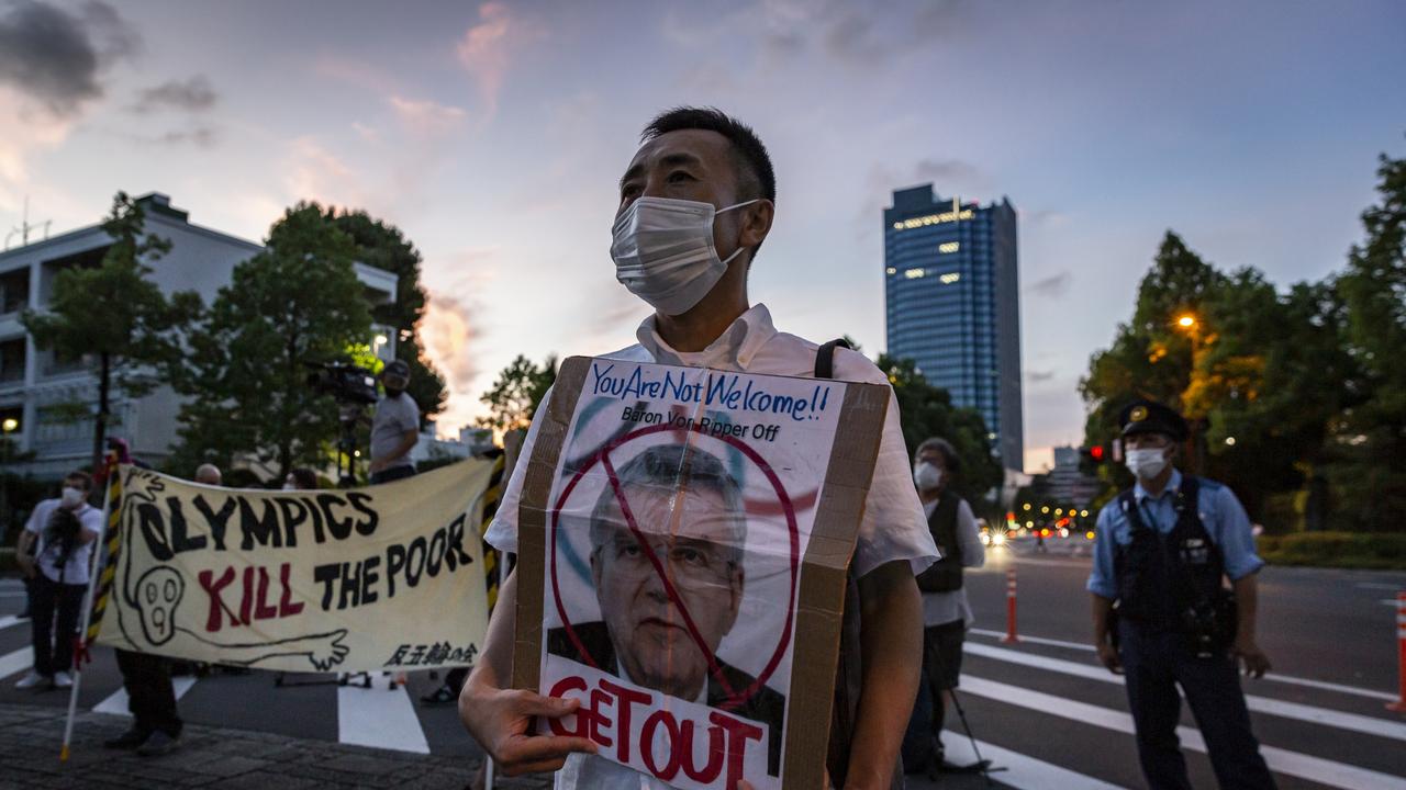 A protester holds a placard with a picture of International Olympic Committee President Thomas Bach.