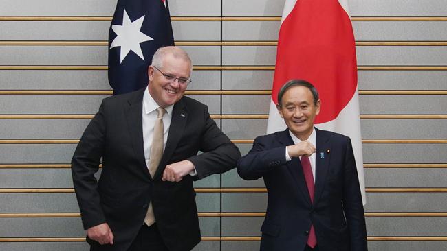 Prime Minister Scott Morrison (L) and Japan's Prime Minister Yoshihide Suga (R) bump elbows as they pose at the start of their bilateral meeting at Suga's official residence in Tokyo.