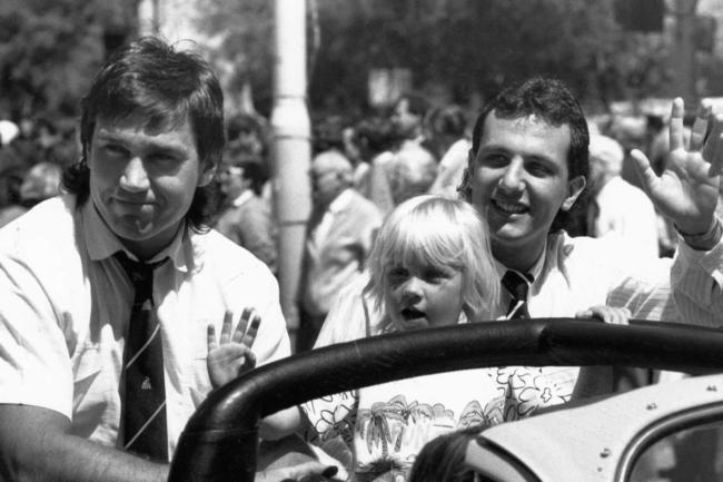 Footballer Greg Phillips with his four-year-old daughter Erin and George Fiacchi at the SANFL grand final cavalcade in 1989.