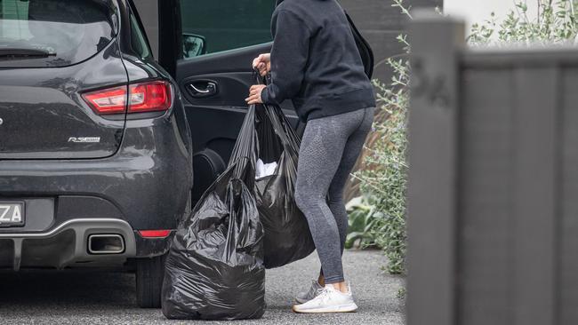 A cleaner removes bags of rubbish after the wild party at the Mornington Airbnb.