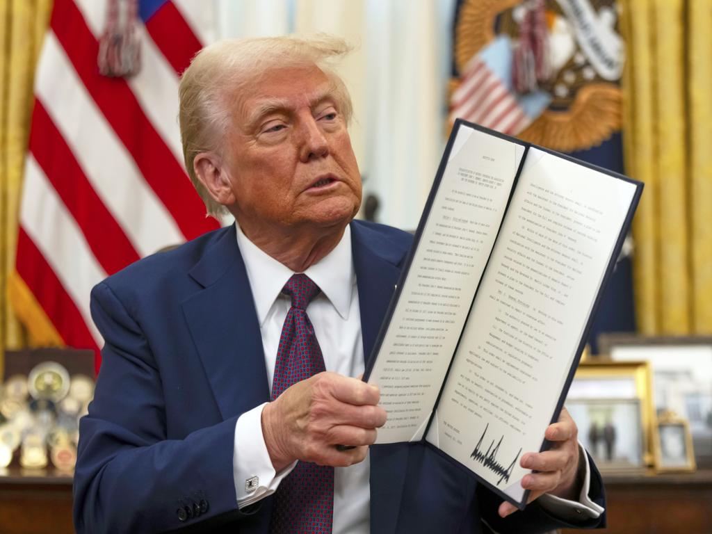 FPresident Donald Trump holds up a signed executive order aiming to declassify remaining federal records relating to the assassinations of President John F. Kennedy, Sen. Robert F. Kennedy, and Martin Luther King Jr. Picture: Ben Curtis/AP