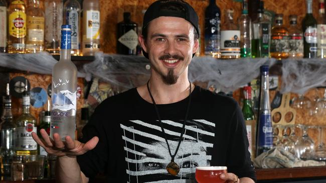 Julian Batley, bartender at Not Tonight shows his balancing skills with a bottle of Grey Gose vodka and a Rumonic cocktail, Southport, Gold Coast. Photo: Regi Varghese