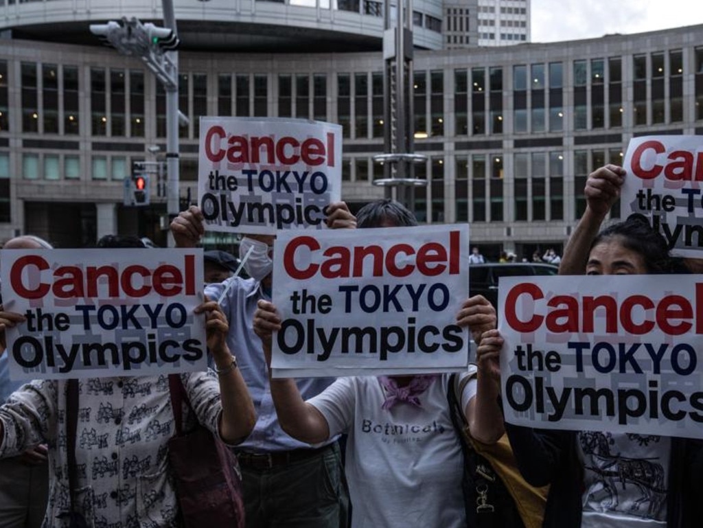 People hold posters during a protest against the Olympic Games in Tokyo. Photo by Carl Court/Getty Images)