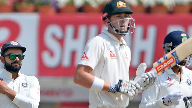 Indian captain Virat Kohli, left, touches his injured shoulder as Australian batsman Matthew Renshaw looks on during the fifth day of the third Test between India and Australia in Ranchi in March, 2017. Picture: AFP/SAJJAD HUSSAIN.