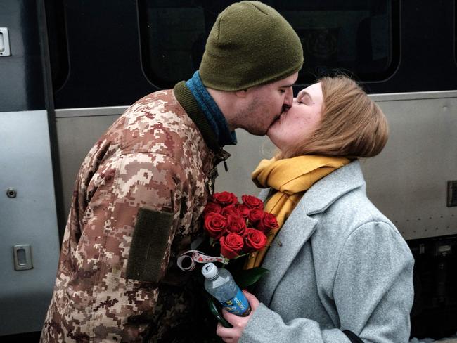 Ukrainian serviceman Maksym kisses his wife Anna as he welcomes her with flowers upon her arrival from Kyiv at the train station in Kramatorsk on Valentine’s Day on February 14, 2023. Picture: Yasuyoshi Chiba / AFP.