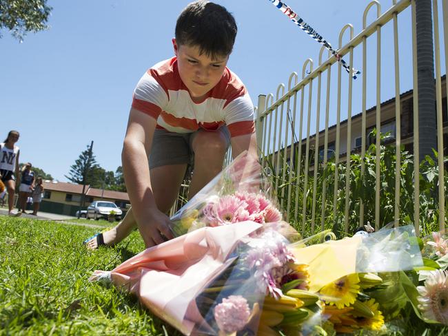 Children lay flowers outside Tateolena’s home after she was killed.