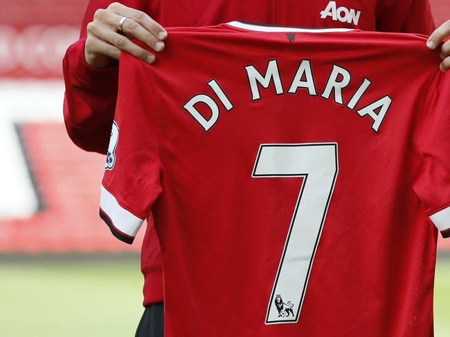 Manchester United's new player Angel Di Maria, pose for photographers, holding his new shirt, at Old Trafford Stadium in Manchester, England, Thursday, Aug. 28, 2014. Manchester United have signed winger Angel Di Maria from Real Madrid for a British record transfer fee of £59.7m. The Argentine winger had a medical in Manchester on Tuesday and has signed a five-year deal. (AP Photo/Alastair Grant)