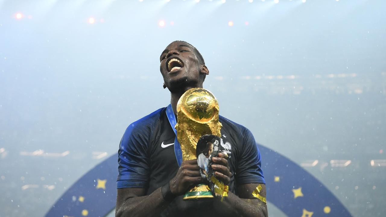 France's midfielder Paul Pogba celebrates with the World Cup trophy.