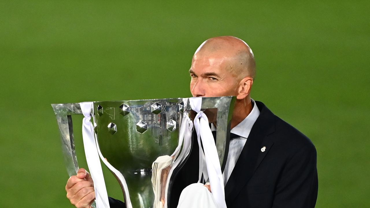 Real Madrid's French coach Zinedine Zidane kisses the La Liga trophy.