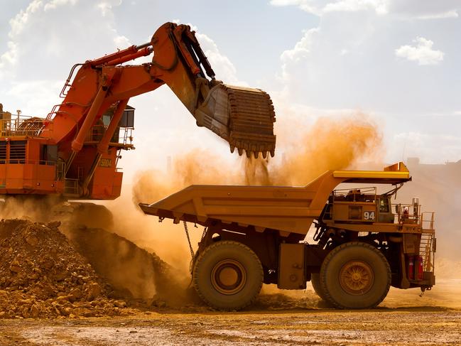 A haul truck is loaded by a digger with material from the pit at Rio Tinto Group's West Angelas iron ore mine in Pilbara, Australia, on Sunday, Feb. 19, 2012. Rio Tinto Group, the world's second-biggest iron ore exporter, will spend $518 million on the first driverless long-distance trains to haul the commodity from its Western Australia mines to ports, boosting efficiency. Photographer: Ian Waldie/Bloomberg via Getty Images