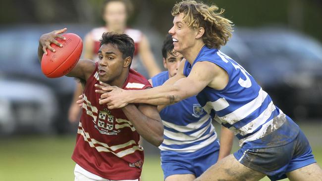 Kysaiah Pickett beaks away from a tackle by St Peter's Sam Dukalskis in a college football match earlier this year. Picture: (AAP Image/Dean Martin