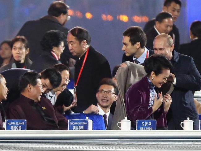 The First Lady smiles before giving the coat to an attendant.