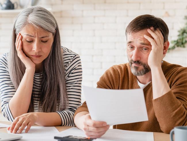 Sad disappointed mature middle-aged couple family wife and husband counting funds, savings, declarations, investments,paperwork, financial documents, bankruptcy, court case, bills, pension at home. Stressed seniors generic