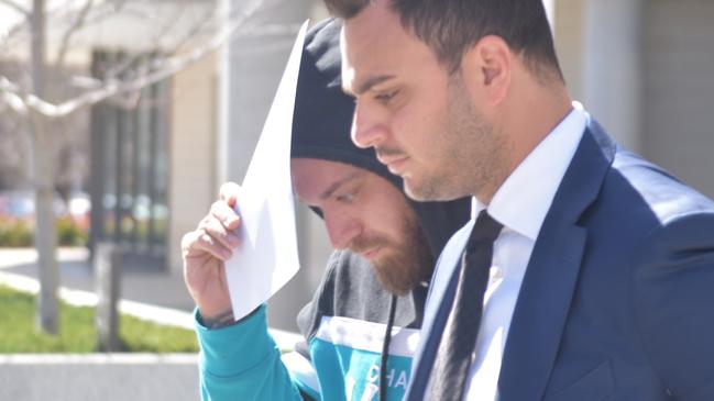 Domenico Luca Costanzo (centre) trying to cover his face after being granted bail in the ACT Magistrates Court on September 13, 2023. Picture: Sam Turner