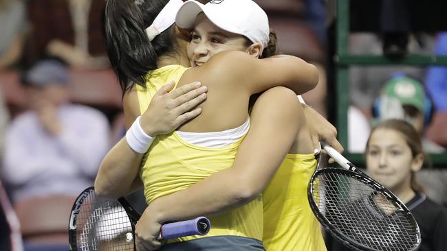 Ashleigh Barty, right, hugs teammate Priscilla Hon after they defeated Danielle Collins and Nicole Melichar. Picture: AP 