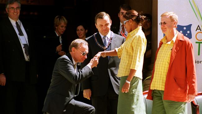 NSW premier Bob Carr kneels before Cathy Freeman at Town Hall for the athletes’ parade with AOC boss John Coates (right) looking on.