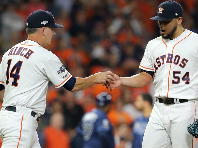 (FILES) In this file photo taken on October 5, 2019 Manager A. J. Hinch of the Houston Astros (L) takes out pitcher Roberto Osuna #54 during the ninth inning of Game 2 of the ALDS against the Tampa Bay Rays at Minute Maid Park in Houston, Texas. - Houston Astros manager A.J. Hinch and team boss Jeff Luhnow have been banned for the 2020 season after a Major League Baseball investigation into allegations of sign-stealing, the league confirmed on January 13, 2020. In sanctions that sent shockwaves through baseball, MLB commissioner Rob Manfred said the Astros had effectively ignored a league warning against illegal sign-stealing issued in 2017. (Photo by Bob Levey / GETTY IMAGES NORTH AMERICA / AFP)