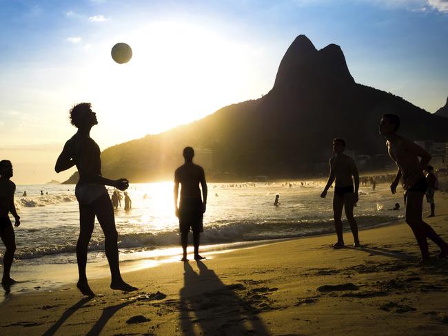 Silhouette of locals playing ball at sunset in Ipanema beach, Rio de Janeiro, Brazil. Photo: iStock