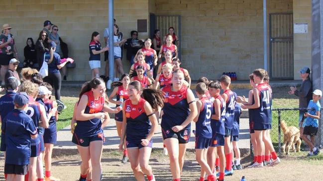 The Surfers Paradise Demons burst onto the field.