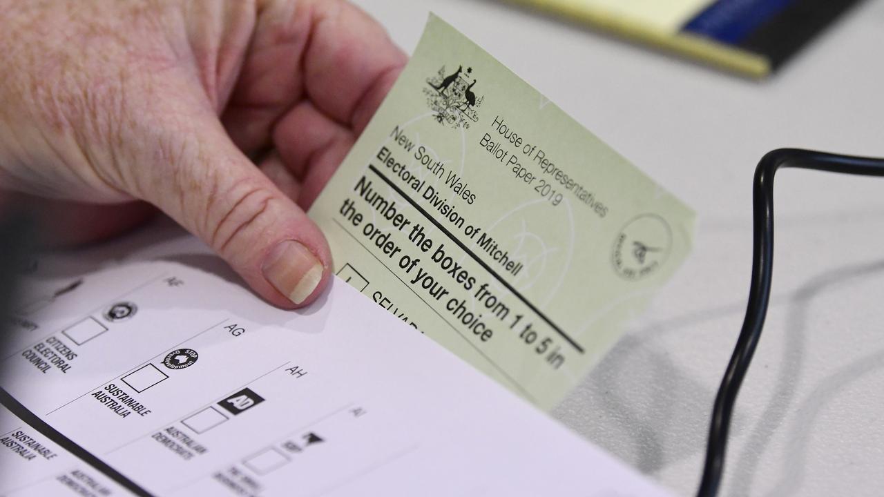 Voters receive a green ballot paper for the House of Representatives and a while ballot paper for the Senate. Picture: AAP Image