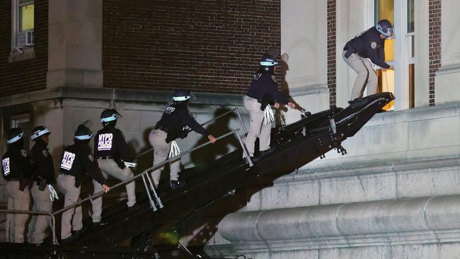 NYPD officers use a laddered truck to break into Columbia University’s Hamilton Hall via a second-floor window on Tuesday night. Picture: AFP