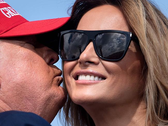 Donald Trump and the First Lady share a kiss on stage at a Florida campaign rally. Picture: AFP