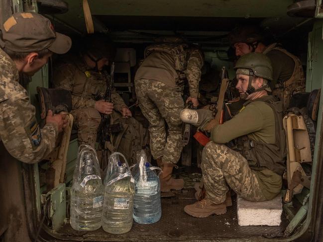 Ukrainian soldiers with their weapons wait inside a US-made M113 armoured personnel carrier to depart for the front in an undisclosed area, in the eastern Donetsk region. Picture: AFP