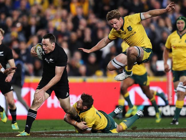 New Zealand's Ben Smith attacks as Australia's Michael Hooper flies high while giving chase. Picture: Brett Costello