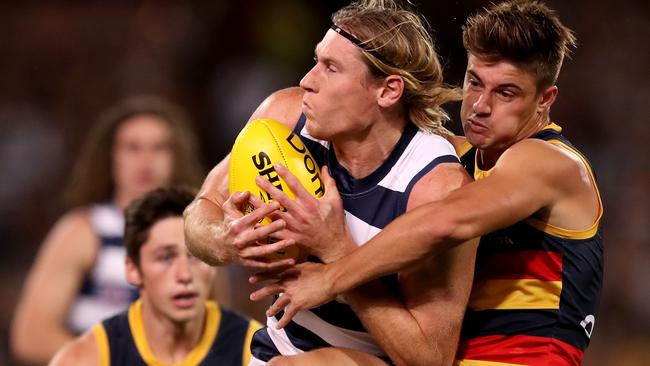 Riley Knight lays a tackle on Geelong’s Mark Blicavs — he says tackling the in-season trade window may be of benefit to players who are seeking an alternative route back to the AFL. Picture: James Elsby / Getty Images