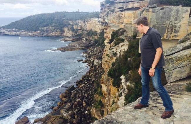 Steve Johnson looks over the cliff at North Head where his brother Scott's body was found in 1988.