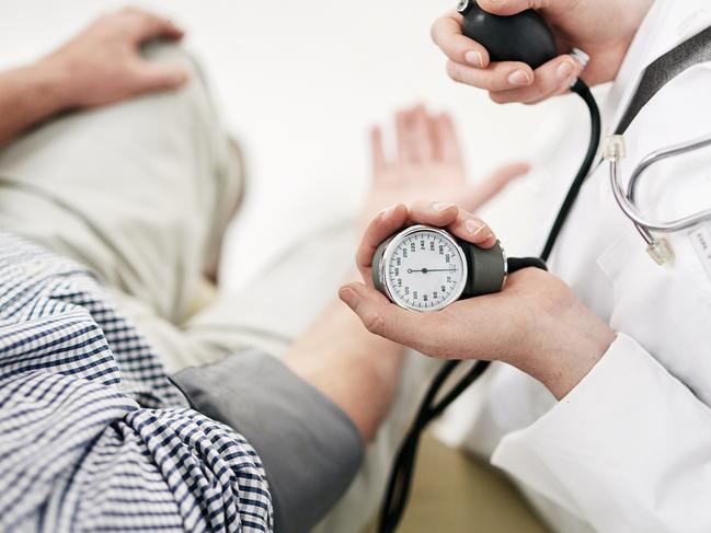 Shot of a doctor checking a senior patient's blood pressure in her office. iStock.