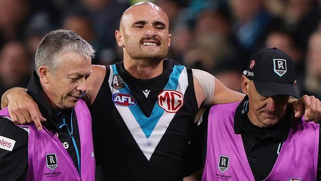 ADELAIDE, AUSTRALIA - APRIL 26: Sam Powell-Pepper of the Power in the hands of medical staff after hurting his knee during the 2024 AFL Round 07 match between the Port Adelaide Power and the St Kilda Saints at Adelaide Oval on April 26, 2024 in Adelaide, Australia. (Photo by Sarah Reed/AFL Photos via Getty Images)