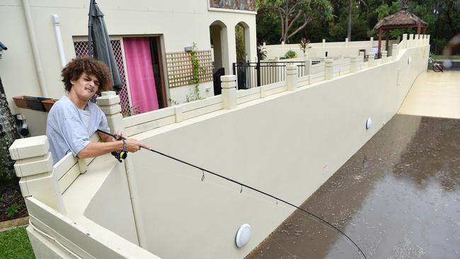 Nirvana Condotels Coolum Beach resident Harley Thompson throws a line into the flooded car park. Picture: Patrick Woods/Sunshine Coast Daily