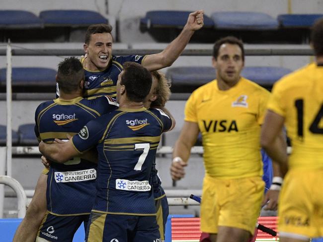 Australia's Brumbies fullback Thomas Banks (top) celebrates with teammates after scoring the team's third try against Argentina's Jaguares during the Super Rugby match at Jose Amalfitani stadium in Buenos Aires, Argentina on May 27, 2017. / AFP PHOTO / JUAN MABROMATA