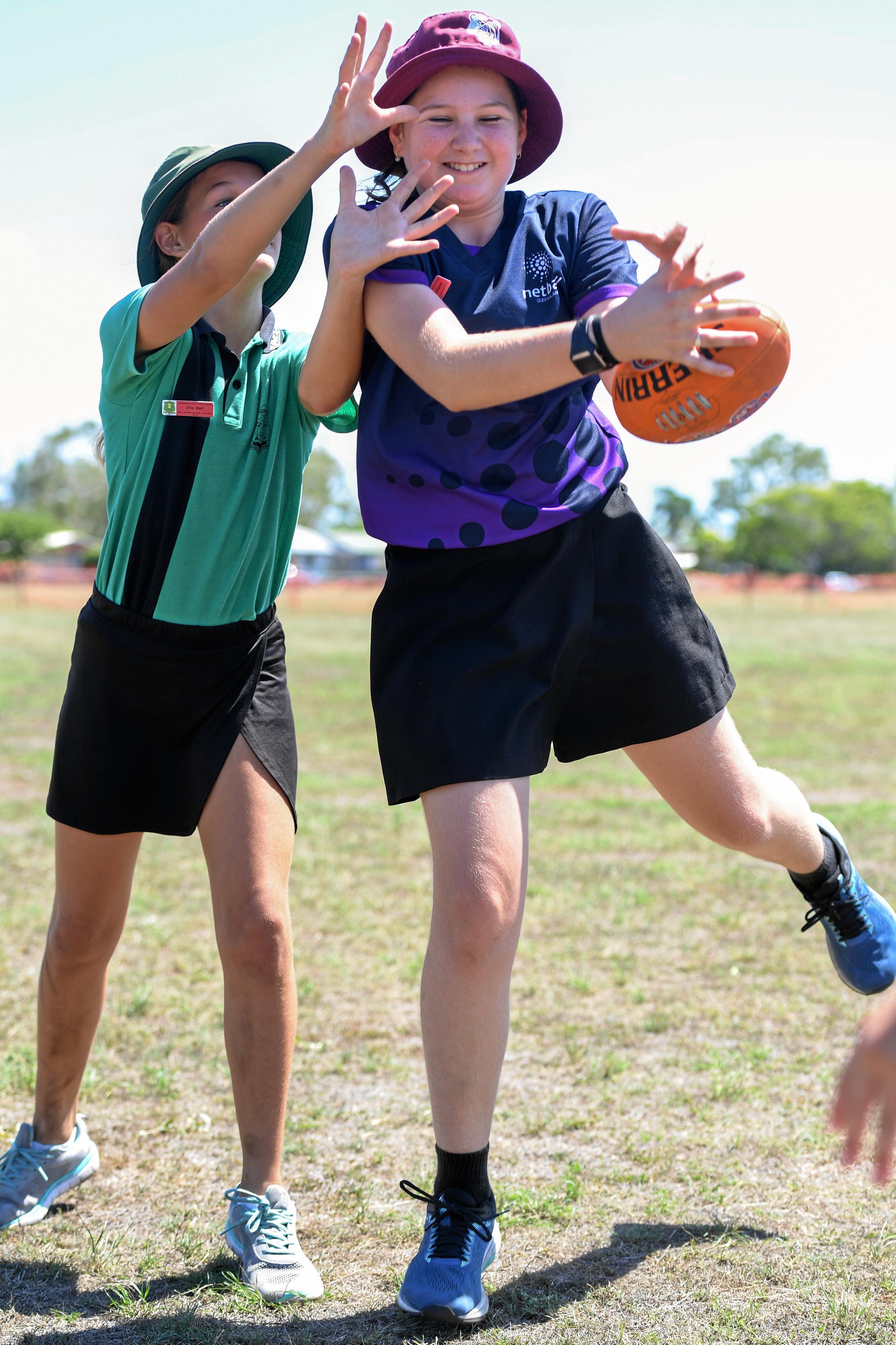 Ella Ball competes with Stella Garland at the Brisbane Lions Aus Kick session at Bundaberg East State School. Picture: Brian Cassidy