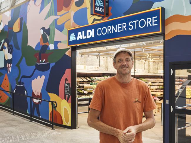 Andrew Dennis in front of his mural.