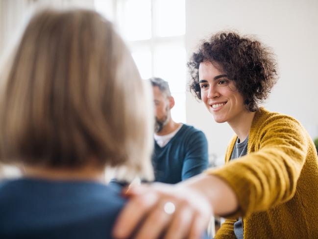 Serious men and women sitting in a circle during group therapy, supporting each other.  - picture istock