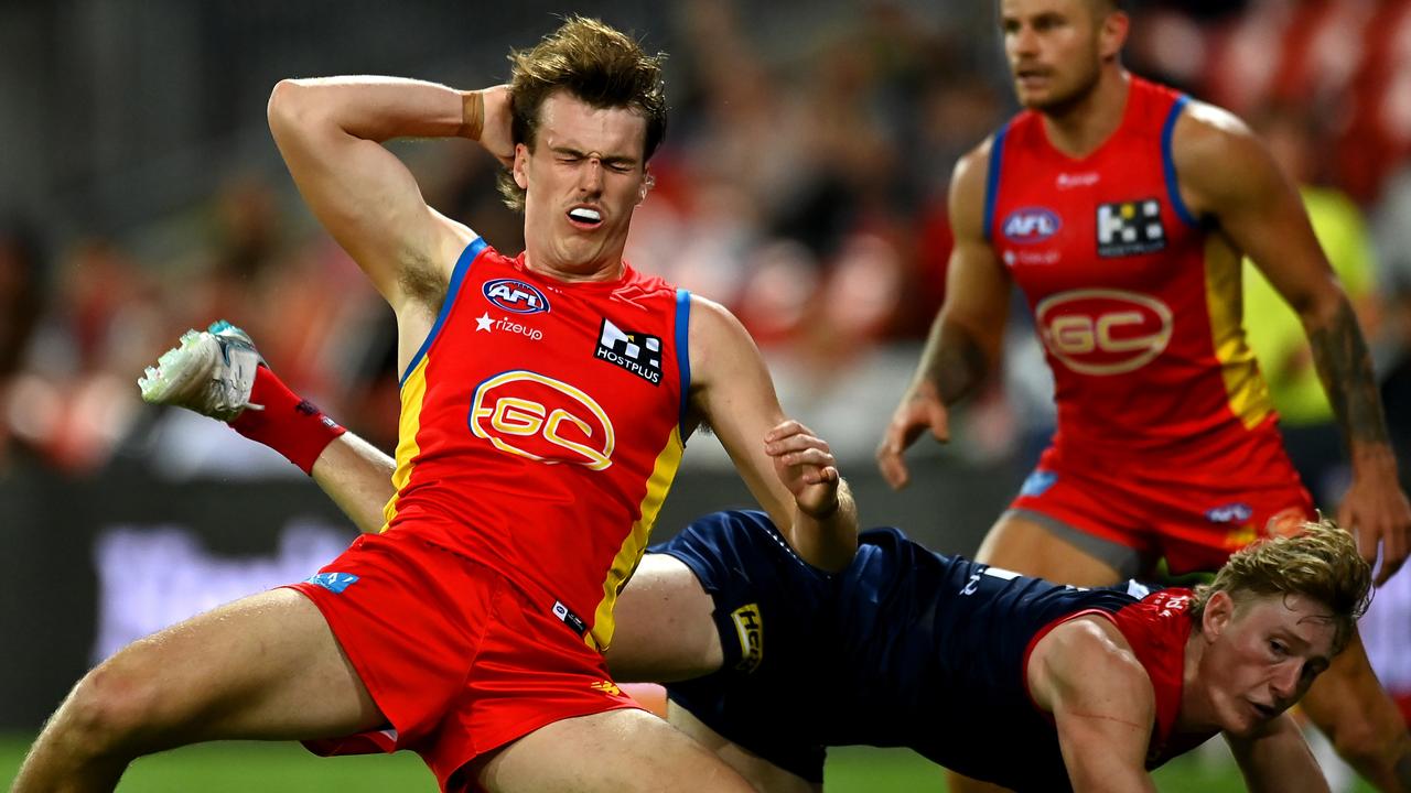 The Suns’ Charlie Ballard falls after being struck by the Demons’ Jacob van Rooyen. Picture: Albert Perez/AFL Photos via Getty Images