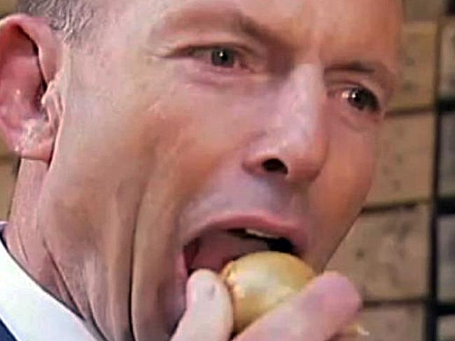 Tony Abbott eating an onion during a visit to Charlton Farm Produce at Moriarty.