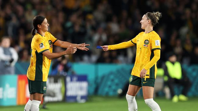 Sam Kerr receives the captain's armband from Steph Catley as she is brought in during the clash against Denmark. Photo by Brendon Thorne/Getty Images.