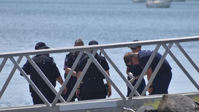 Police investigate the scene on the banks of the Burnett River and interview boaties following a serious boat crash.