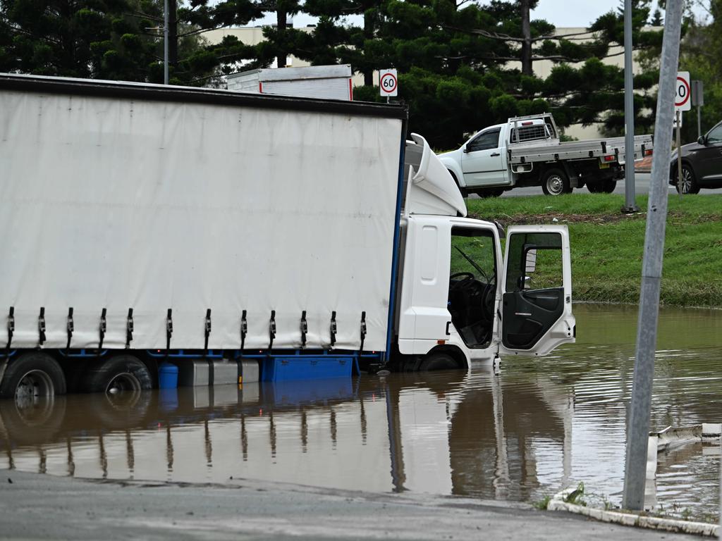 Partly submerged trucks in floods near the Puma service station in Strathpine.