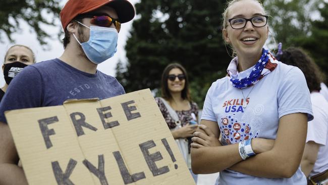 Georgia Lacroix speaks to a man holding a ‘Free Kyle’ sign outside a school where President Donald Trump was meeting with law enforcement. Picture: Angus Mordant for NewsCorp Australia