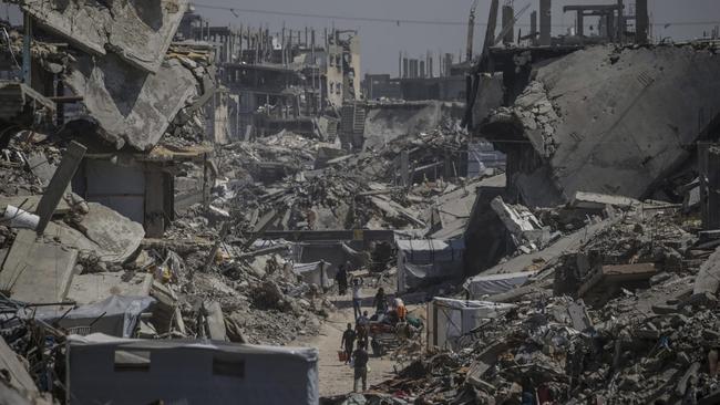 Displaced Gazans follow a path through wrecked buildings in the Jabalia refugee camp last month. Picture: Mohammed Saber/Shutterstock