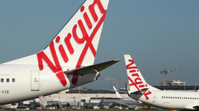 The Virgin Australia Holdings Ltd. logo is displayed on the tails of a Boeing Co. 737-800, left, and a Boeing Co. 737-8FE aircraft preparing to take off at Sydney Airport in Sydney, Australia, on Monday, Feb. 8, 2016. Virgin Australia is scheduled to announce half-year earnings on Feb. 11. Photographer: Brendon Thorne/Bloomberg