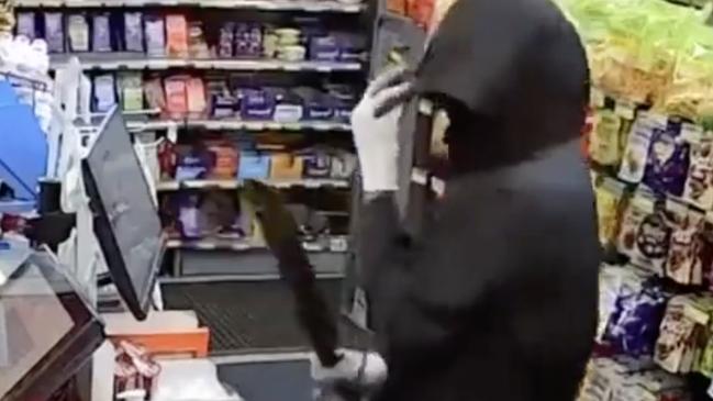 Frightening security vision has captured the moment a machete-wielding robber stormed a North Adelaide convenience store and terrorised a worker. Picture: 7NEWS,
